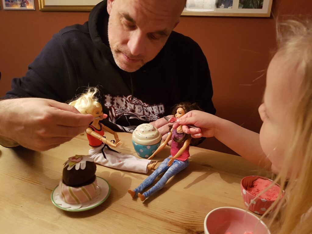 Papa und Tochter spielen mit Barbie