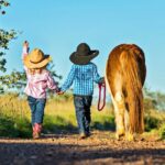 Little cowgirl and cowboy with pony