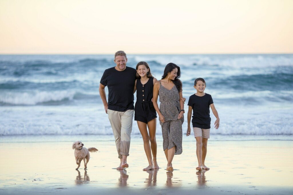 eltern und zwei kinder mit hund am strand