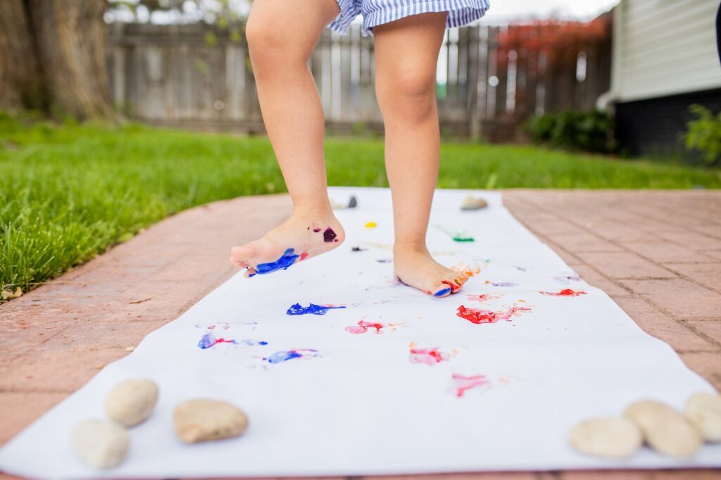 Raus geht's - 5 Outdoor-Ideen für KiTa-Kinder zum Spielen & Lernen 7 Mit den Füßen zu malen ist für Kinder eine tolle Outdoor-Aktivität