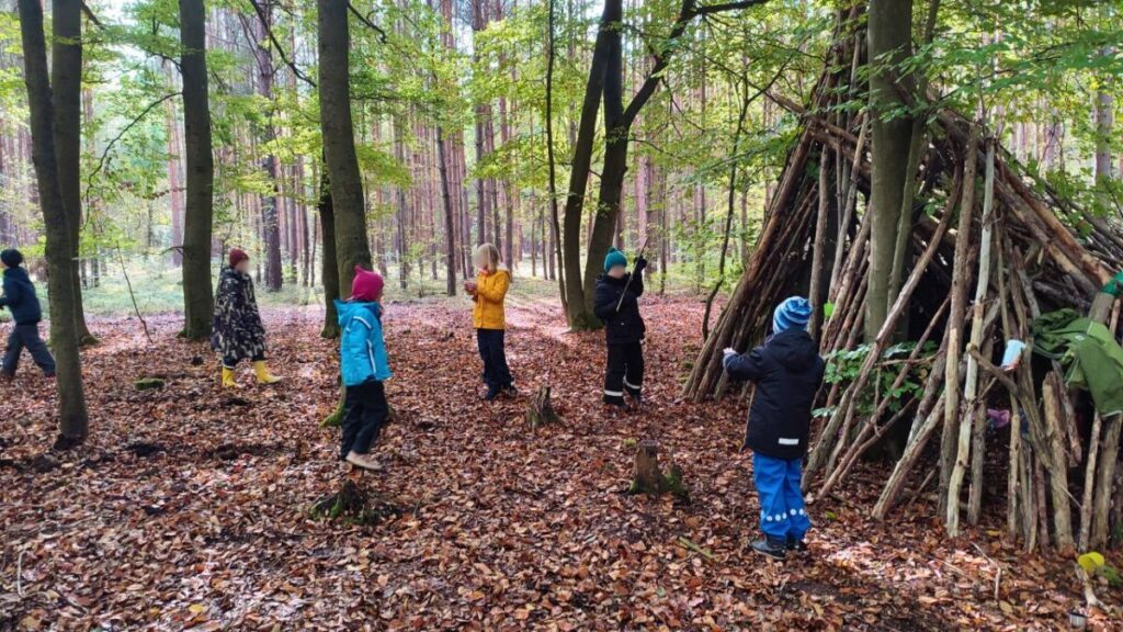 10 Spiele im Wald, die deine Kinder lieben werden 7 kinder im wald huette gebaut spielen natur